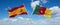 two crossed flags Cameroon and spain waving in wind at cloudy sky. Concept of relationship, dialog, travelling between two