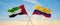 two crossed flags Colombia and United Arab Emirates waving in wind at cloudy sky. Concept of relationship, dialog, travelling