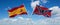 two crossed flags confederate battle or Dixie flag and spain waving in wind at cloudy sky. Concept of relationship, dialog,