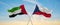 two crossed flags Czech Republic and United Arab Emirates waving in wind at cloudy sky. Concept of relationship, dialog,