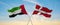 two crossed flags denmark and United Arab Emirates waving in wind at cloudy sky. Concept of relationship, dialog, travelling