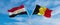 two crossed flags Egypt and Belgium waving in wind at cloudy sky. Concept of relationship, dialog, travelling between two