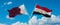 two crossed flags Egypt and Qatar waving in wind at cloudy sky. Concept of relationship, dialog, travelling between two countries