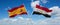 two crossed flags Egypt and spain waving in wind at cloudy sky. Concept of relationship, dialog, travelling between two countries