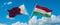 two crossed flags Hungary and Qatar waving in wind at cloudy sky. Concept of relationship, dialog, travelling between two