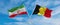 two crossed flags Iran and Belgium waving in wind at cloudy sky. Concept of relationship, dialog, travelling between two countries