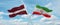 two crossed flags Iran and Latvia waving in wind at cloudy sky. Concept of relationship, dialog, travelling between two countries