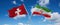 two crossed flags Iran and Switzerland waving in wind at cloudy sky. Concept of relationship, dialog, travelling between two