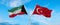 two crossed flags Kuwait and Turkey waving in wind at cloudy sky. Concept of relationship, dialog, travelling between two