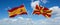 two crossed flags Macedonia and spain waving in wind at cloudy sky. Concept of relationship, dialog, travelling between two