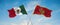 two crossed flags Montenegro and mexico waving in wind at cloudy sky. Concept of relationship, dialog, travelling between two
