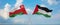 two crossed flags Palestine and Oman waving in wind at cloudy sky. Concept of relationship, dialog, travelling between two