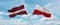 two crossed flags poland and Latvia waving in wind at cloudy sky. Concept of relationship, dialog, travelling between two