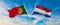 two crossed flags portugal and Netherland waving in wind at cloudy sky. Concept of relationship, dialog, travelling between two