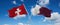 two crossed flags Qatar and Switzerland waving in wind at cloudy sky. Concept of relationship, dialog, travelling between two