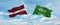 two crossed flags Saudi Arabia and Latvia waving in wind at cloudy sky. Concept of relationship, dialog, travelling between two
