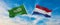 two crossed flags Saudi Arabia and Netherland waving in wind at cloudy sky. Concept of relationship, dialog, travelling between
