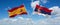 two crossed flags Serbia and spain waving in wind at cloudy sky. Concept of relationship, dialog, travelling between two countries