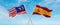 two crossed flags Spain and Malaysia waving in wind at cloudy sky. Concept of relationship, dialog, travelling between two