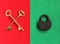 Two crossed golden keys on red felt and close padlock on green f