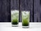 Two crystal glasses filled with layered matcha soda