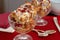 Two crystal goblets filled with Italian Panettone cranberry bread pudding with sauceboat in background