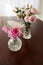 Two crystal vases with roses and miniature flowers