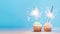 Two cupcakes decorated with sparklers, copy space