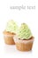 Two cupcakes with green cream isolated on white background