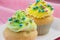 Two cupcakes with yellow and green buttercream