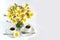 Two cups of coffee and a bouquet of camomiles on a white background