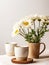 Two cups of coffee and bouquet of daisies in a vase.