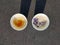 Two cups of coffee with cornflowers and saffron standing on asphalt with shadows