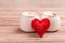 Two cups of coffee with decorative felt heart on wooden background close-up. The Concept Of Valentine`s Day, Christmas