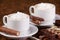 Two cups of coffee or hot cocoa with chocolates and cookies on