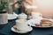 Two cups of coffee and tiramisu on black table background with beautiful latte art heart shaped.