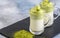Two cups Dalgona Matcha Latte, a creamy whipped matcha, on light background