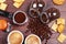 Two cups of espresso, crackers, cookies, holder with ground coffee, tamper and cans of coffee beans on wooden table