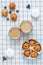 Two cups of foamy latte and muffins, blueberries, marshmallows on a checkered tablecloth. Breakfast concept. Flatlay design
