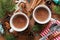 Two cups of fresh hot cocoa or hot chocolate on wooden christmas background