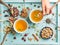 Two cups of healthy herbal tea with mint, cinnamon, dried rose, camomile flowers in spoons and man\'s hand holding spoon