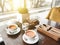 Two cups of healthy herbal tea with sea-buckthorn, ginger and honey on a textured light wooden table in a sunlit cafe