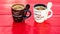 Two cups of homemade expresso coffee on red wooden board