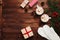 Two cups of hot cocoa or chocolate with marshmallow, gifts, mittens, christmas decor and fir tree on wooden background above.