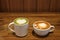 Two cups of hot drink for lover in valentine which are matcha latte and coffee late with heart pattern milk froth on the surface