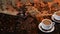 Two cups with latte on saucer with the coffee beans