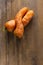 Two curved ugly carrots on brown old wooden background with copy soace. Vegetables with unusual strange shape. Vertical