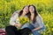 Two curvy girls in a field of daisies laugh happy in a daisy field