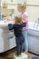 Two cute adorable blond caucasian siblings washing face and cleaning tooth with toothbrush at bathroom at home in