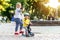 Two Cute adorable little caucasian siblings boy in helmet and girl having fun riding three-wheeled balance run bike